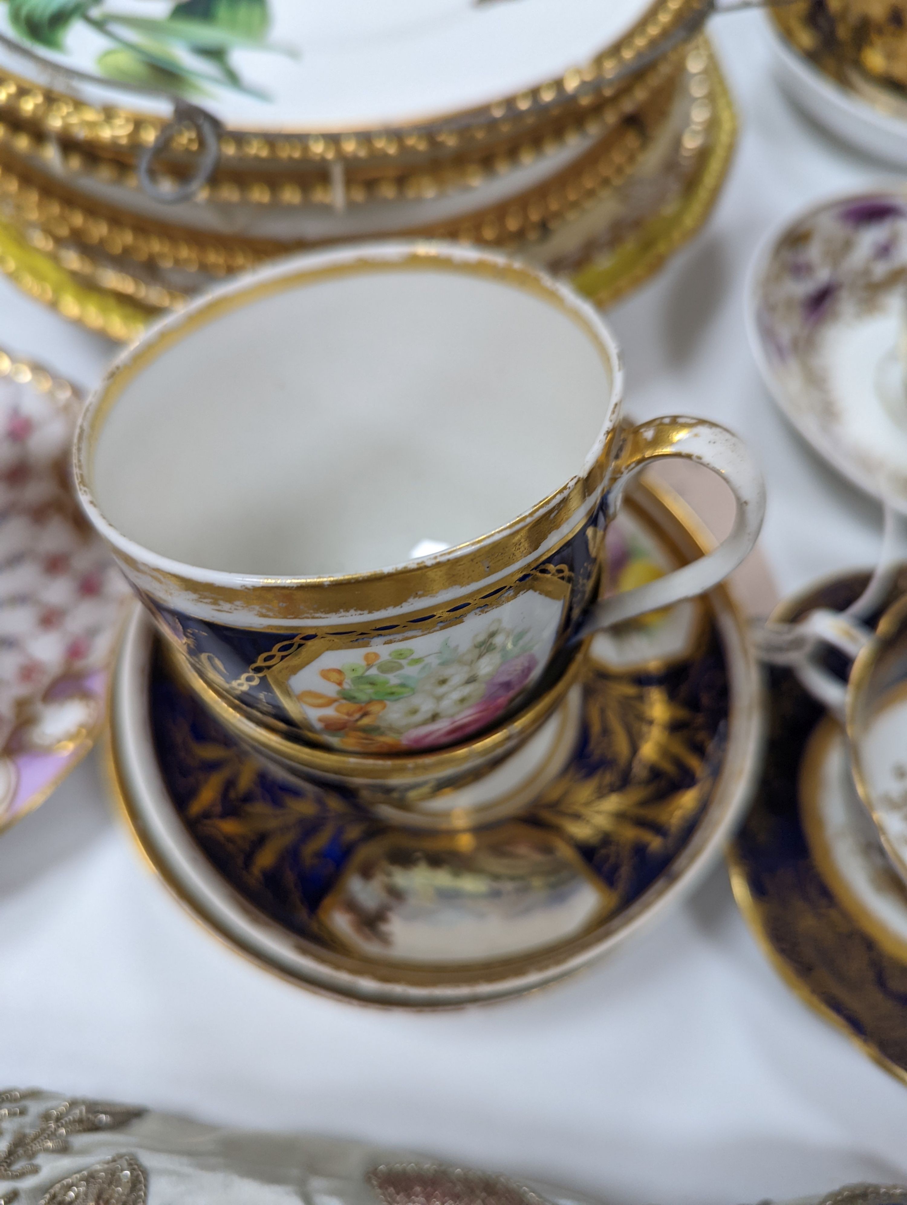 A small collection of Victorian porcelain tea cups and saucers and sundry dessert plates